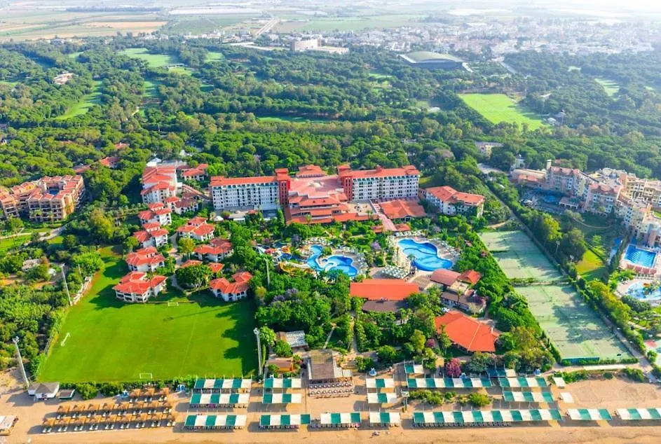 Belconti Resort Hotel Belek Exterior photo This is an aerial photograph showcasing a large, sprawling resort complex nestled within a lush, green landscape.

**Key features in the image include:**

*   **The Resort:** A significant portion of the center of the image is dominated by the resort